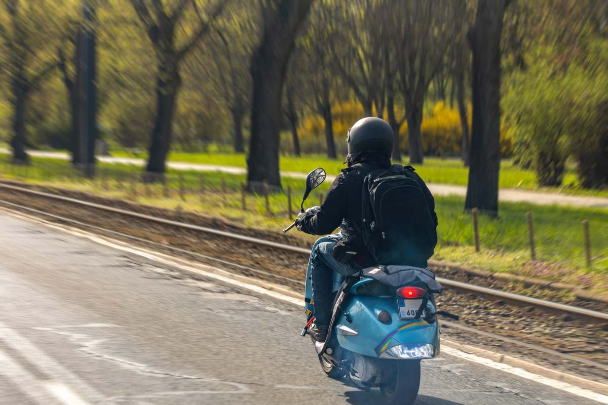 Kierowca skutera hamuje na ulicy w mieście