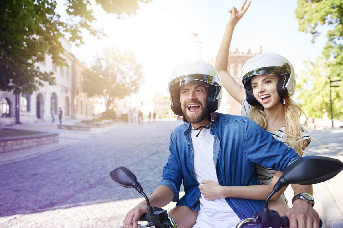 Kierowca i pasażer na motocyklu w kaskach i kurtkach
